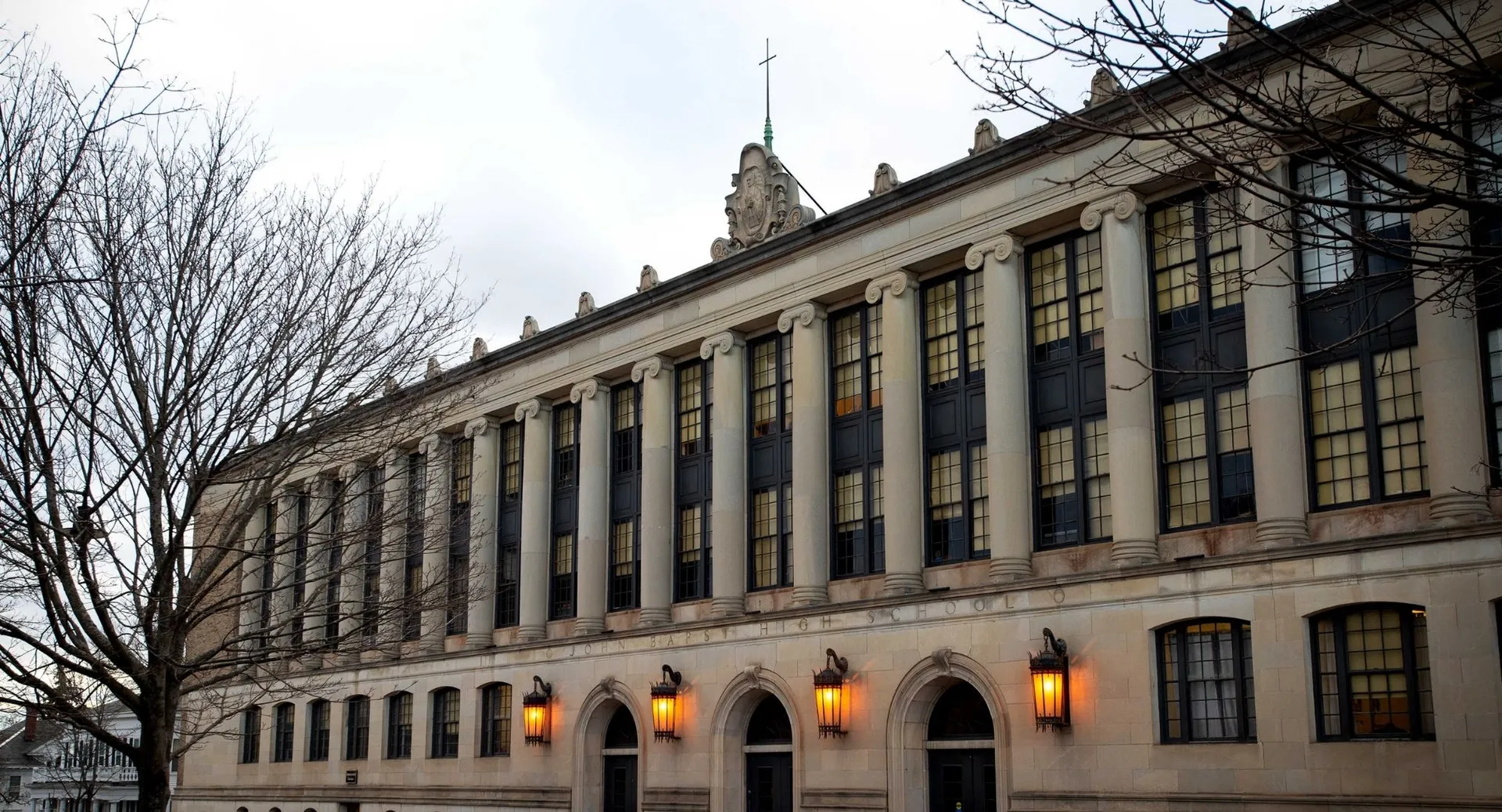 Il magnifico edificio con finestre ad arco nel campus della John Bapst Memorial High School è circondato da alberi spogli.