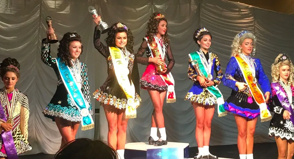 Un gruppo di giovani donne in costumi colorati si trova sul palco del Sancta Maria College Ballyroan.
