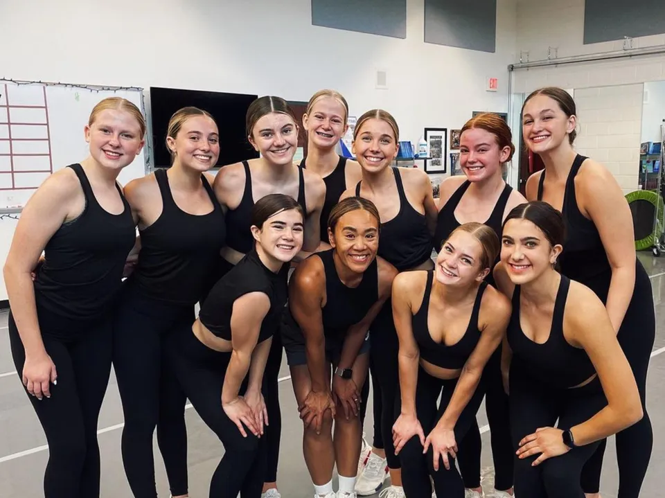 Un gruppo di studentesse della Arcadia High School posa in uno studio di danza indossando abiti da ballo neri.