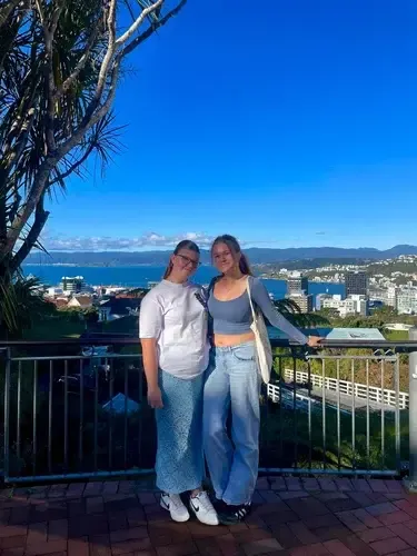 Dos chicas en un mirador sobre la bahía de Wellington y sus colinas