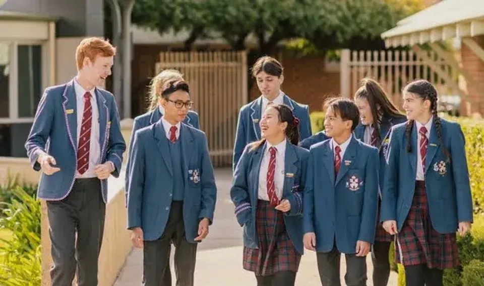 Un gruppo di studenti in divisa scolastica cammina nel campus della John Septimus Roe Anglican Community School.