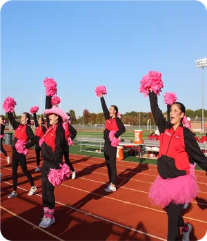 Cheerleaderinnen in pinken Trikots auf der Laufbahn