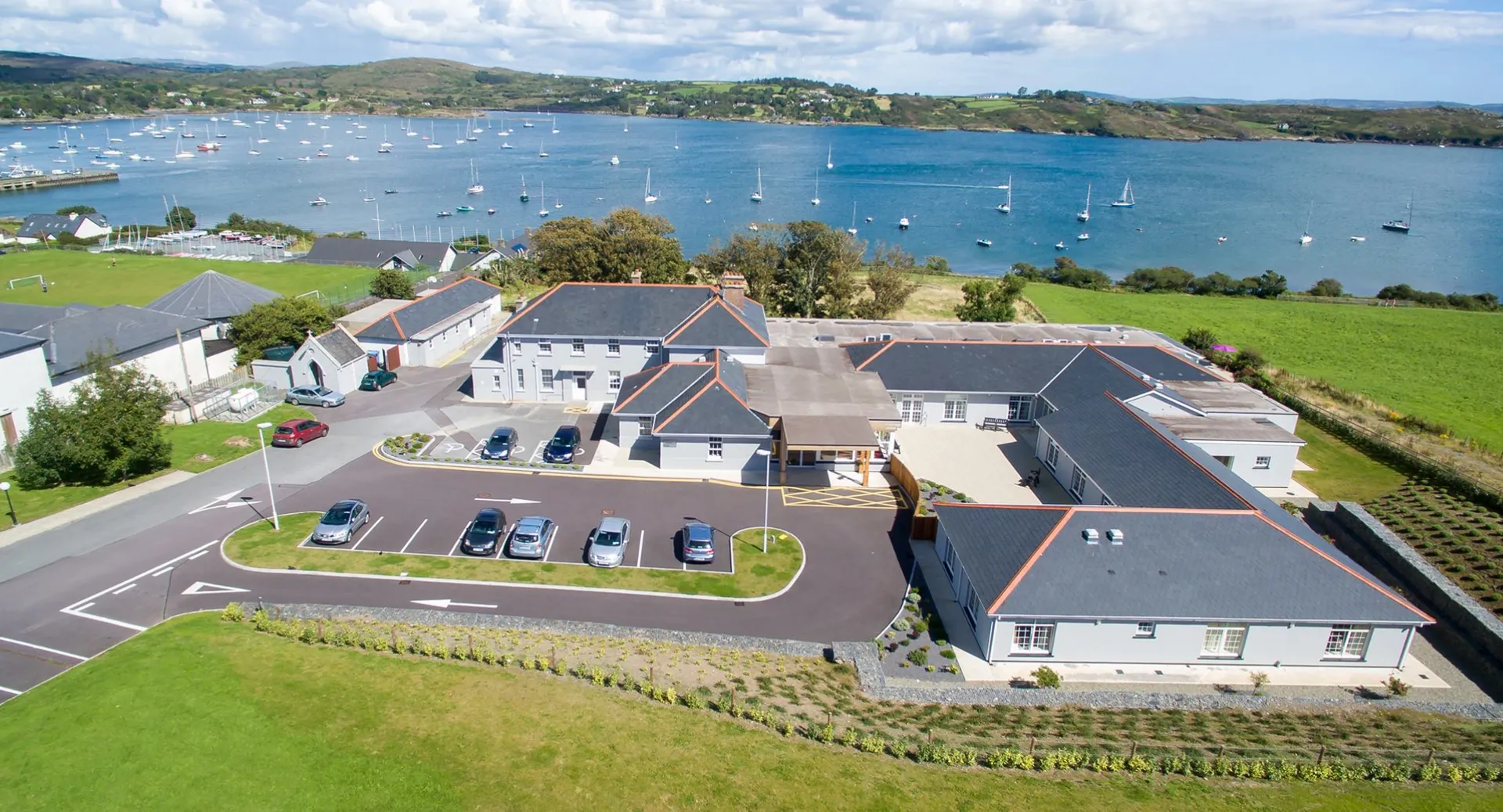 Vista sul porto e sugli edifici residenziali circostanti nella città costiera vicino al Schull Community College.