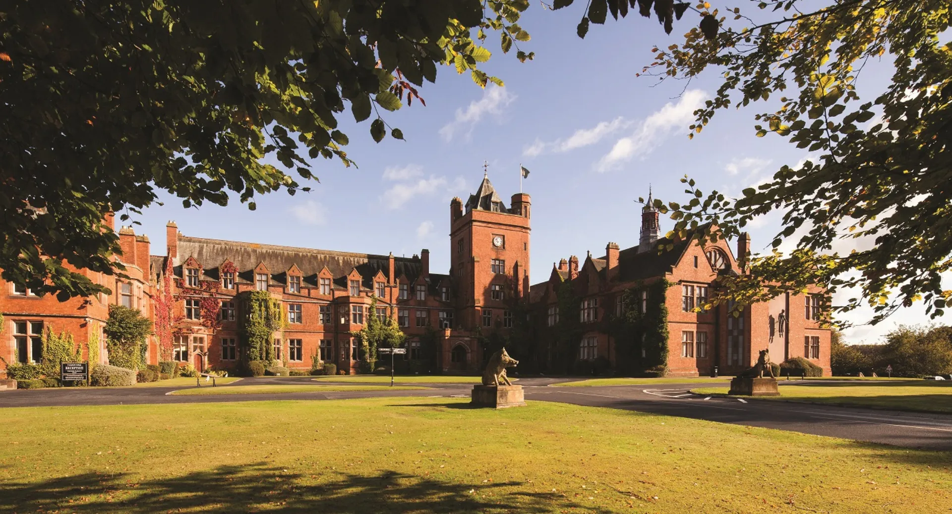 L'edificio principale storico della Fyling Hall School si trova in un cortile verde sotto un cielo azzurro.
