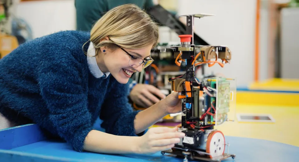 Una studentessa della South Carleton High School si concentra sulla riparazione di un dispositivo meccanico nel laboratorio.