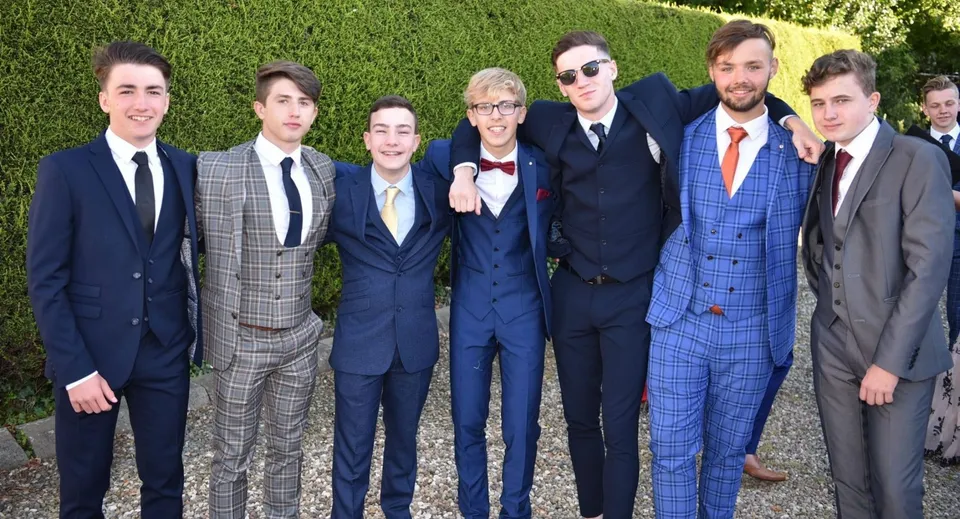 Un gruppo di persone posa insieme durante un evento nel verde del campus della Wells Cathedral School.