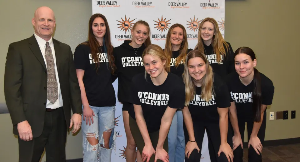 Un gruppo di giovani donne della Deer Valley Unified School indossa t-shirt abbinate con O'Connor Volleyball davanti a un logo Deep Valley.