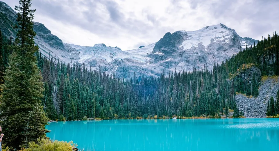 Un tranquillo lago alpino con montagne innevate e foreste di sempreverdi nei dintorni della Vincent Massey Secondary School.
