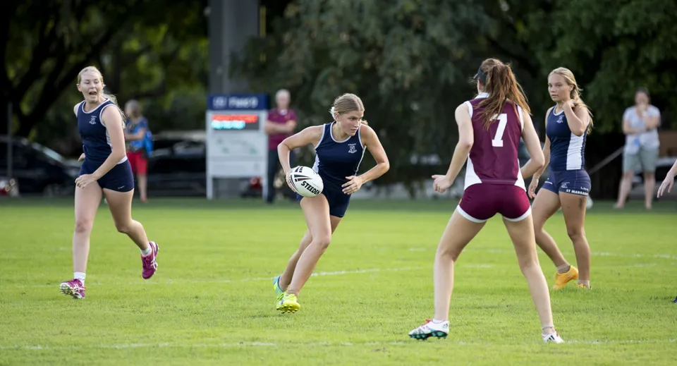 Un gruppo di atlete corre su un campo sportivo nel campus della St. Margaret's School.