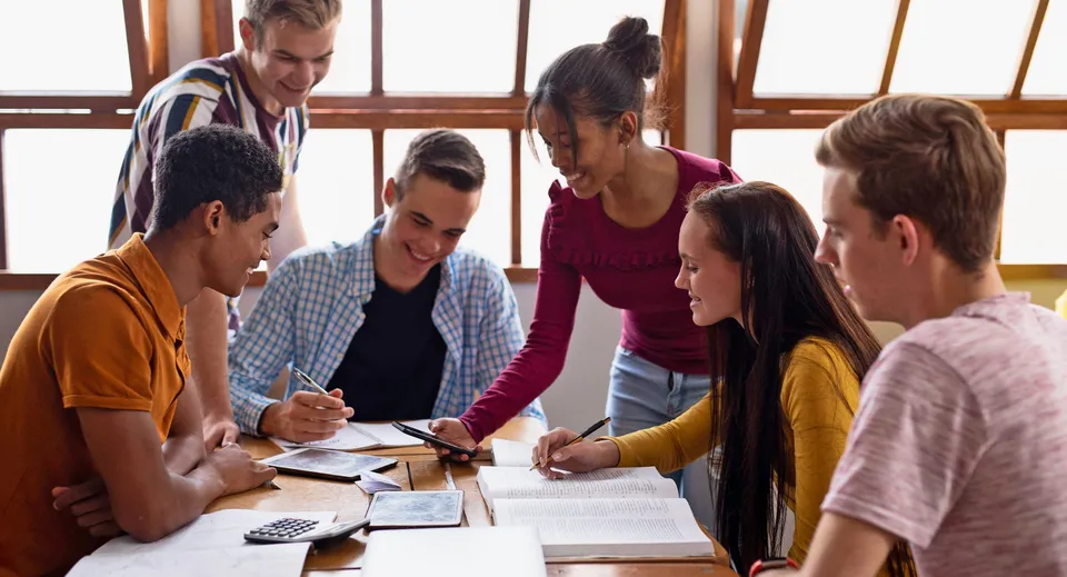 Un gruppo di studenti della Ardscoil Phadraig discute e lavora insieme a un tavolo.
