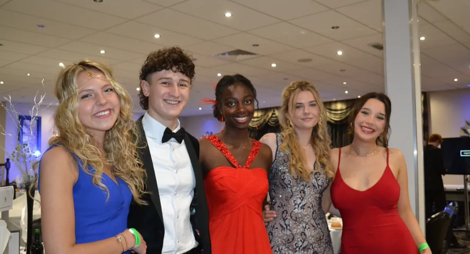Un gruppo di cinque giovani adulti in abito formale durante una festa nel campus della Frensham Heights School.