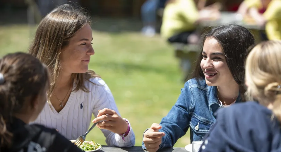 Due studentesse della Earlscliffe chiacchierano vivacemente su un prato all'aperto.