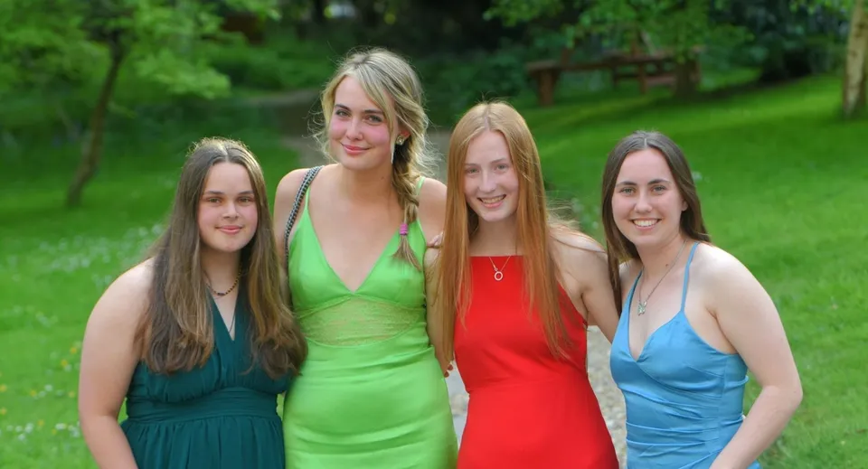 Quattro studentesse della Truro School sono insieme in un'area verde all'aperto.