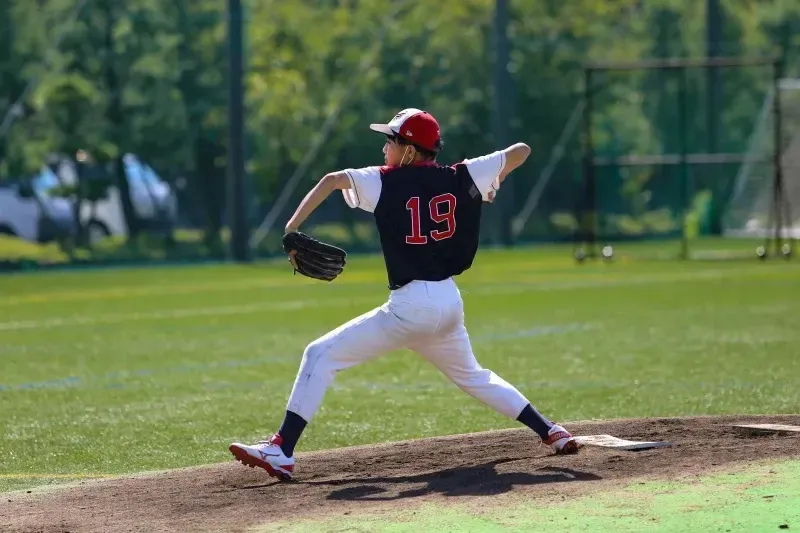 Eine junge Baseballspielerin steht auf dem Pitcher's Mound auf dem Sportgelände der Canadian Academy.