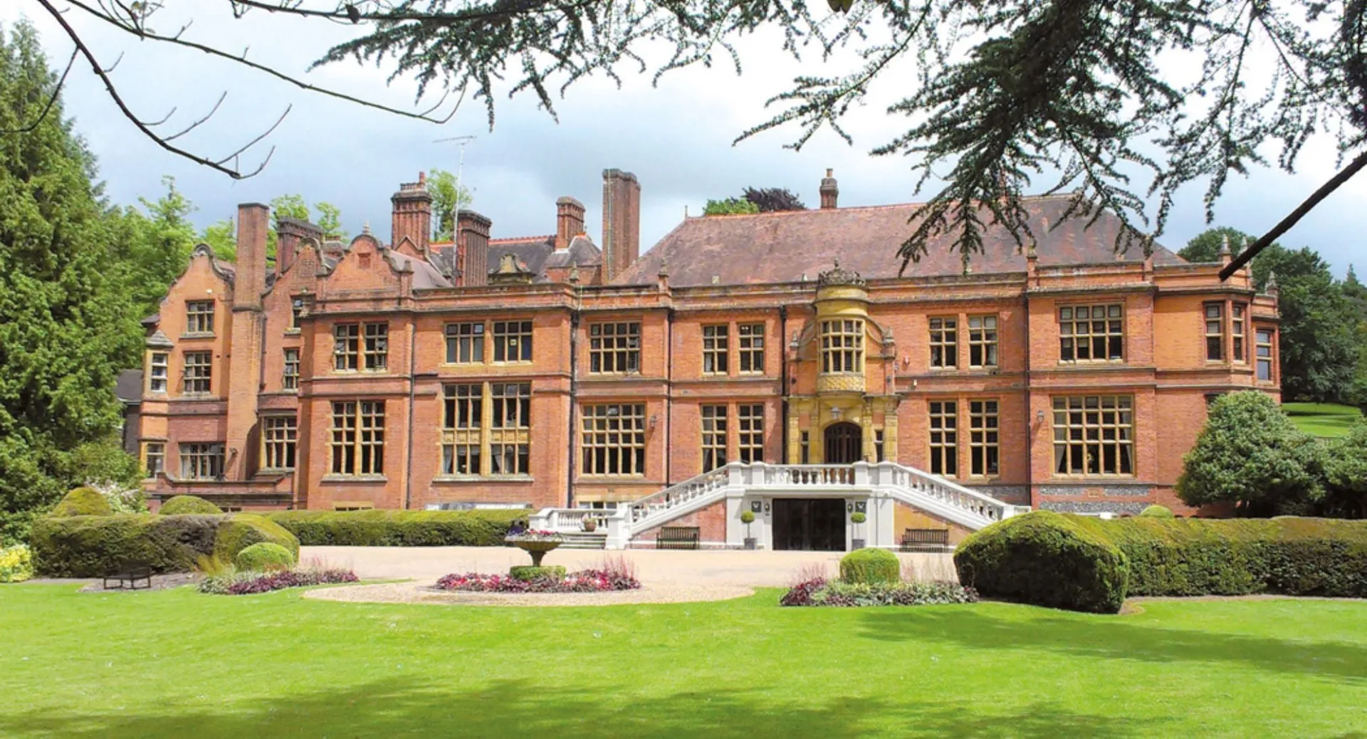 L'edificio principale storico della Woldingham School sorge circondato da un giardino ben curato con un prato verde.