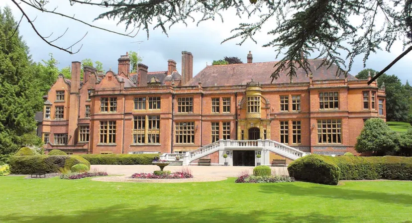 Il magnifico edificio in mattoni della Woldingham School è circondato da un giardino ben curato con un prato verde.