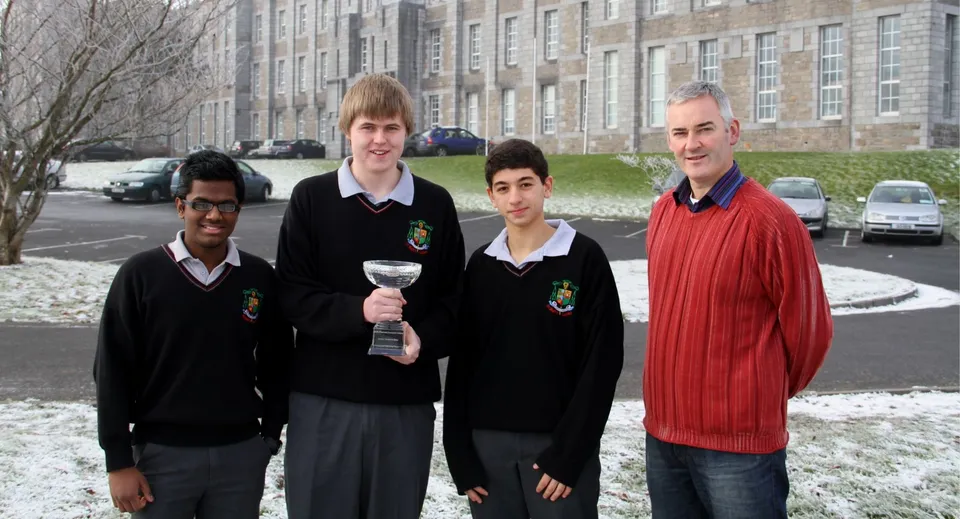 Quattro studenti in divisa scolastica sono in piedi con la neve davanti a un edificio del campus del St. Marys College Galway.
