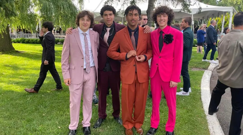 Un gruppo di cinque persone in abiti colorati si trova nel parco del campus della Westwood High School.