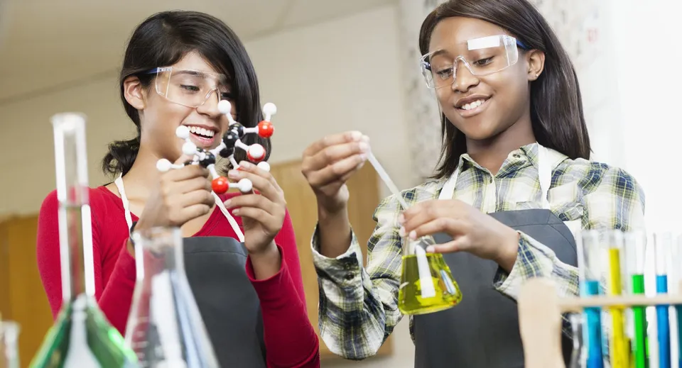 Due studenti del Coláiste Pobail Acla chiacchierano ed esaminano insieme qualcosa in laboratorio.