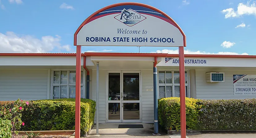 L'ingresso con un grande cartello di benvenuto e il logo della Robina State High School.