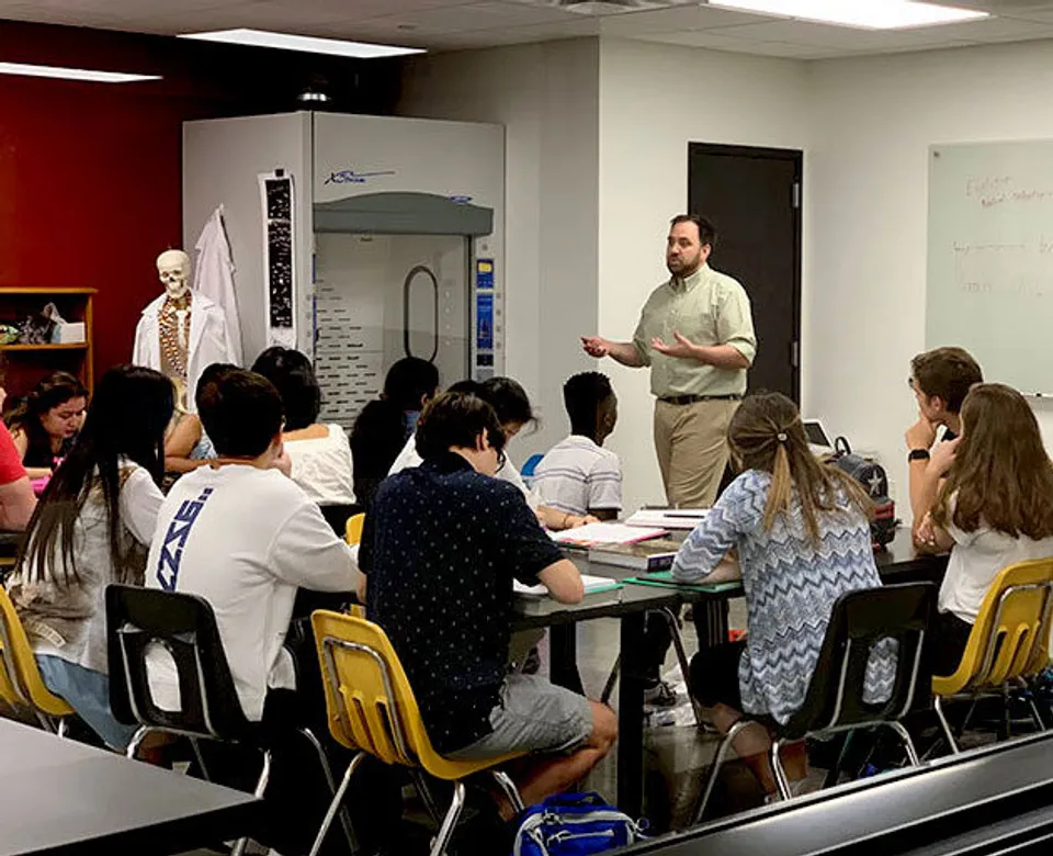 Gli studenti della Rivermont Collegiate sono seduti in classe e ascoltano un insegnante.