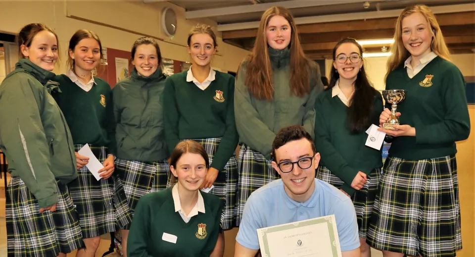 Un gruppo di studentesse della Coláiste Íosagáin posa insieme a un trofeo a scuola.