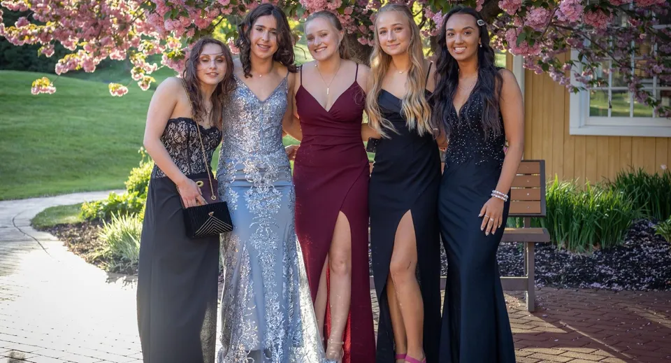 Cinque studentesse in abito da sera posano insieme all'aperto nel campus della St. Mary's Secondary School a Charleville.
