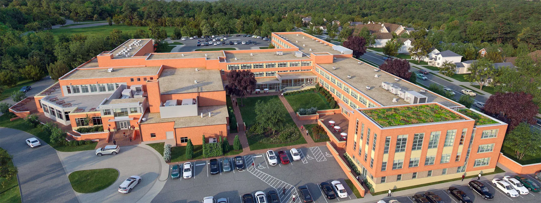 El edificio de varias plantas de la Saint Johns High School con tejado naranja está en un aparcamiento ante un fondo arbolado.