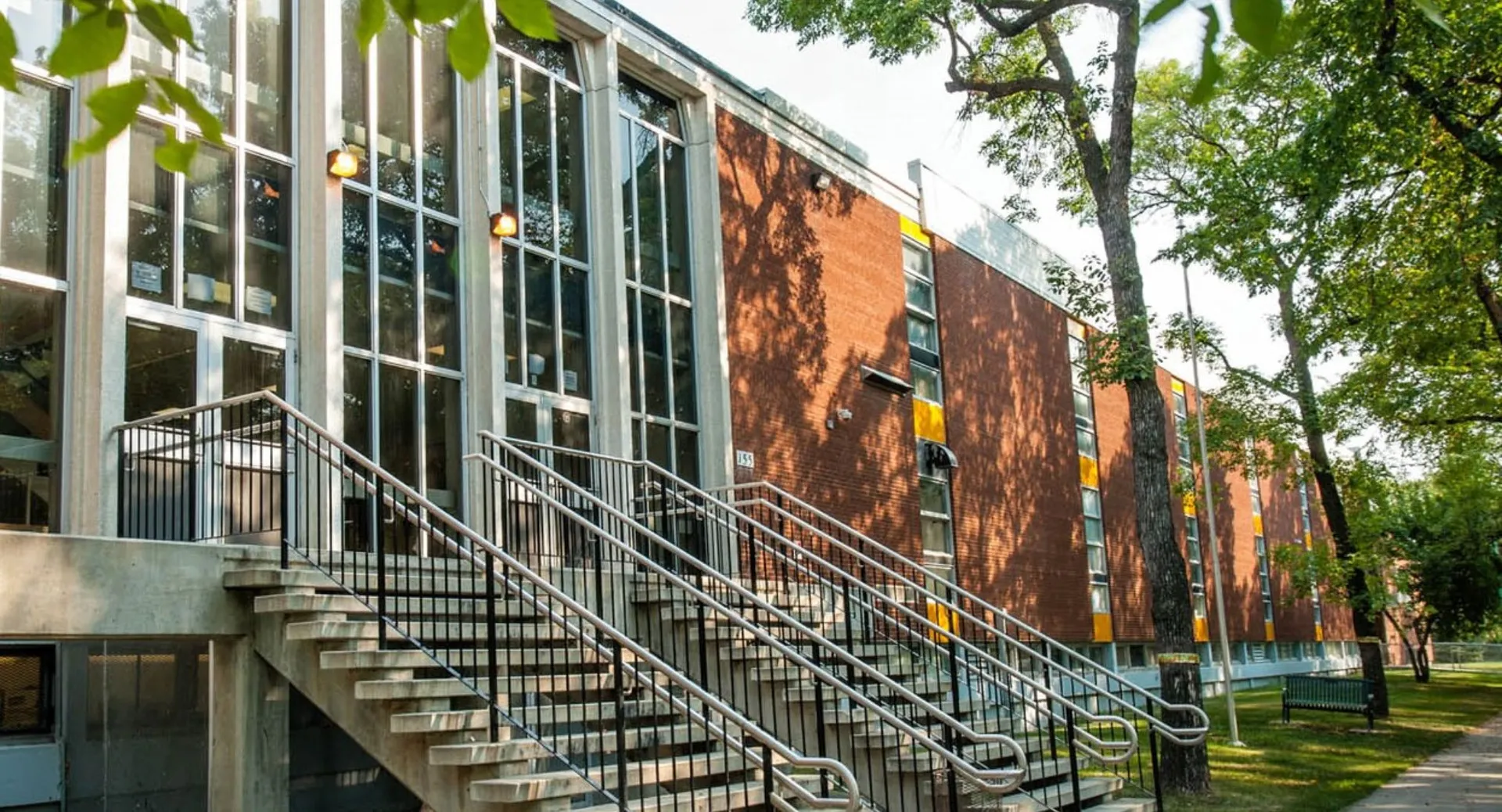 L'edificio in mattoni a più piani della Kelvin High School è circondato da alberi e da un prato.