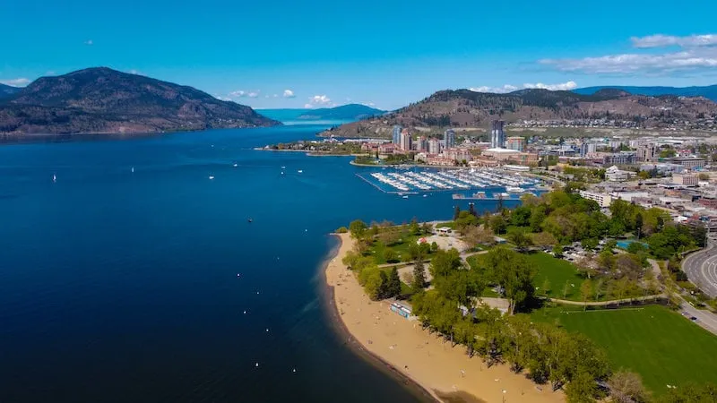 Vista de la ciudad costera con montañas y un lago cerca de la École de l'Anse-au-sable.