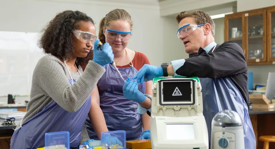 Tre medici della Dunn School esaminano un dispositivo medico in un laboratorio.