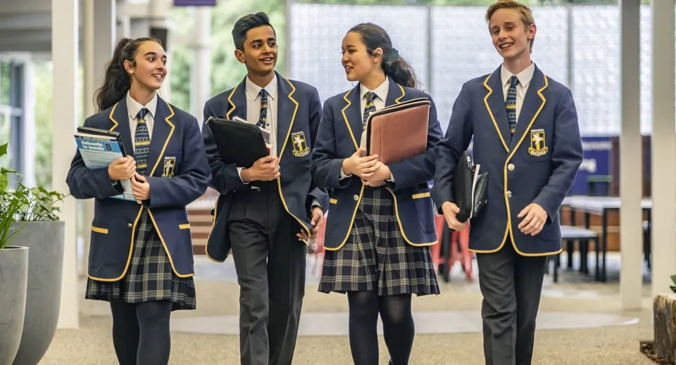 Un gruppo di studenti in divisa scolastica si trova nel corridoio del campus dell'Immanuel College.