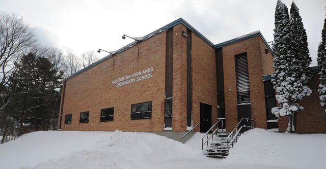 L'edificio scolastico della Haliburton Highlands School si trova in un paesaggio innevato con pini visibili sullo sfondo.
