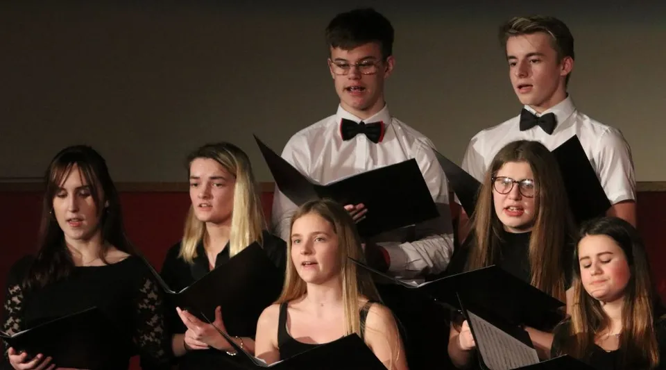 Un gruppo di studenti della Wisbech Grammar School canta insieme durante una rappresentazione.