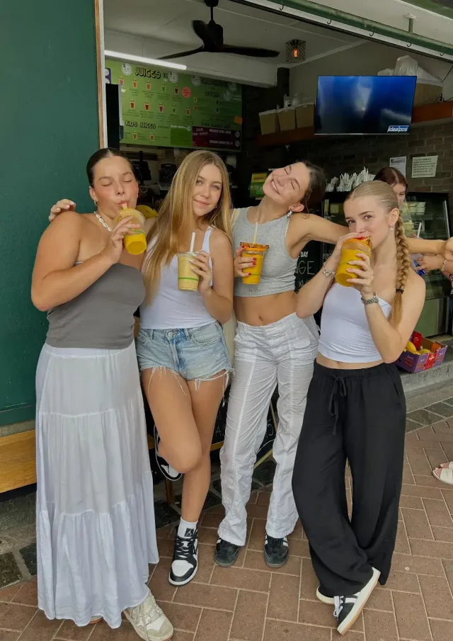 Gruppo di studentesse con frullati davanti a un chiosco di succhi in Australia