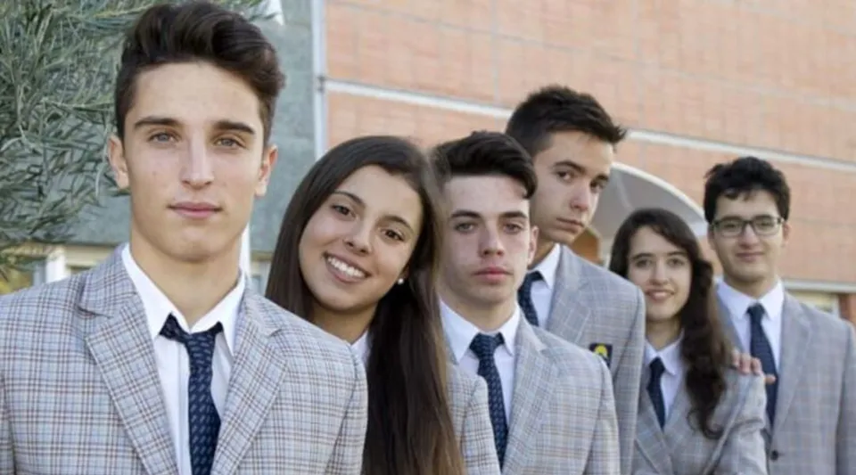 Un gruppo di studenti della Laude Lady Elizabeth School in piedi insieme davanti a un muro di mattoni.