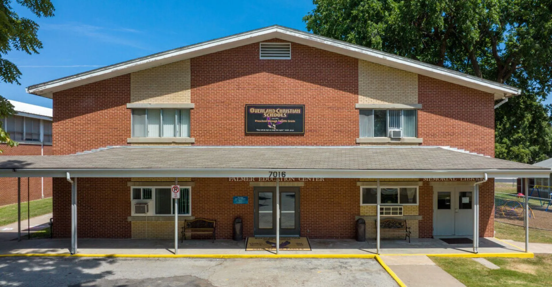 Il Coon Creek Community Center nel campus delle Overland Christian Schools si trova in un'area erbosa con alberi sullo sfondo.
