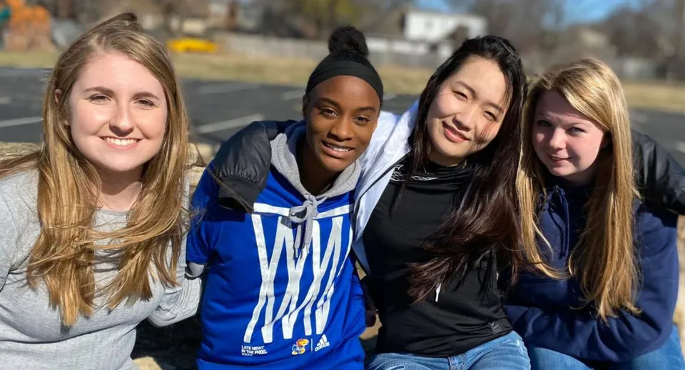 Quattro studentesse della Plaza Heights Christian Academy sono insieme all'aperto in una giornata di sole.