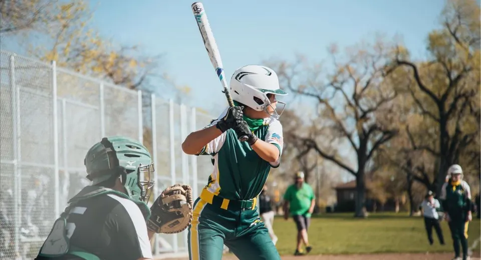 Una studentessa in divisa da baseball si trova sul campo da gioco della St. Joseph Catholic High School.