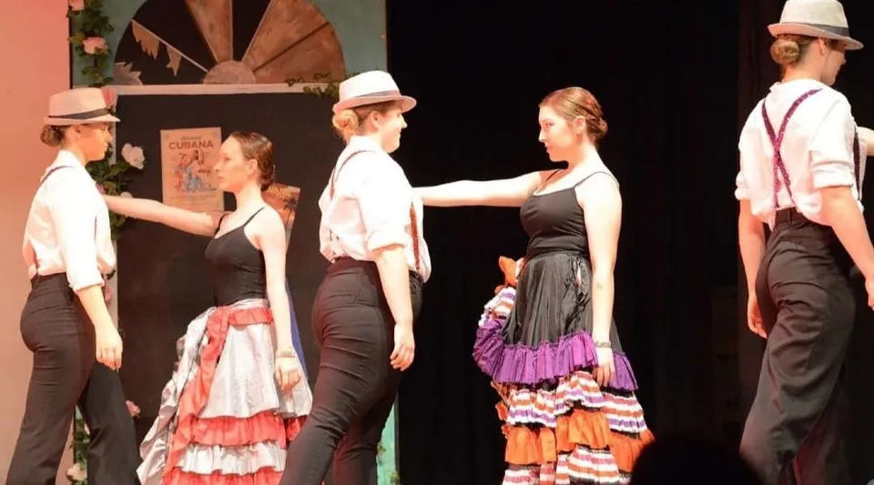 Studenti della Kaiapoi High School in abiti tradizionali spagnoli durante un'esibizione di danza sul palco.