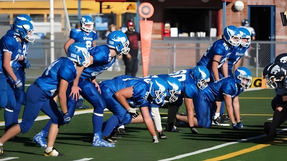 Studenti della Crescent Heights High School si radunano in maglia blu sul campo da calcio con un edificio sullo sfondo.