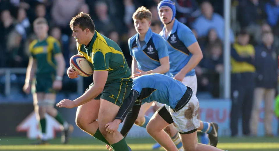 Un giocatore di rugby porta la palla durante una partita sul campo della Woodhouse Grove School.