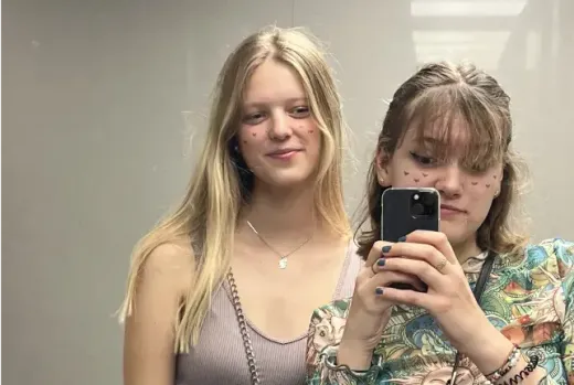 Zwei Mädchen machen ein Spiegel-Selfie mit dem Smartphone in Spanien