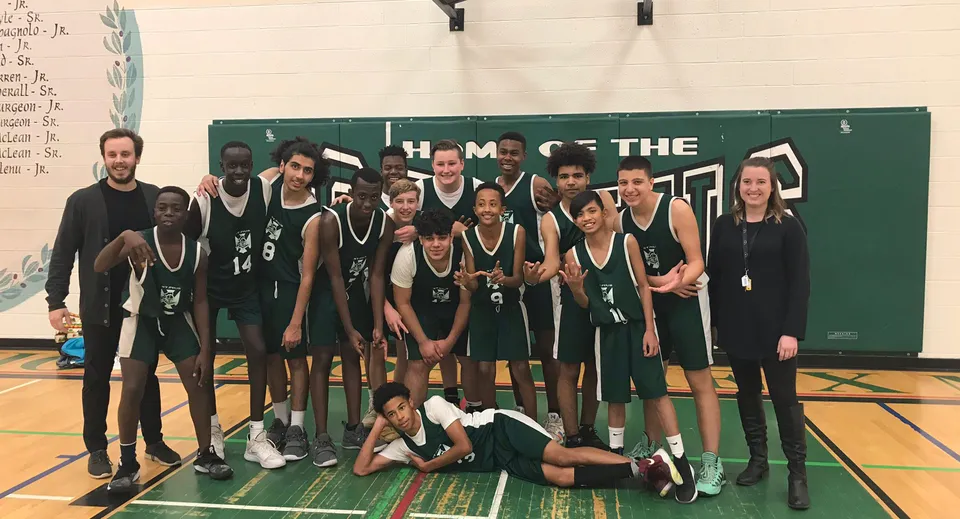 La squadra di pallacanestro della St. Pius X High School posa insieme nella palestra.