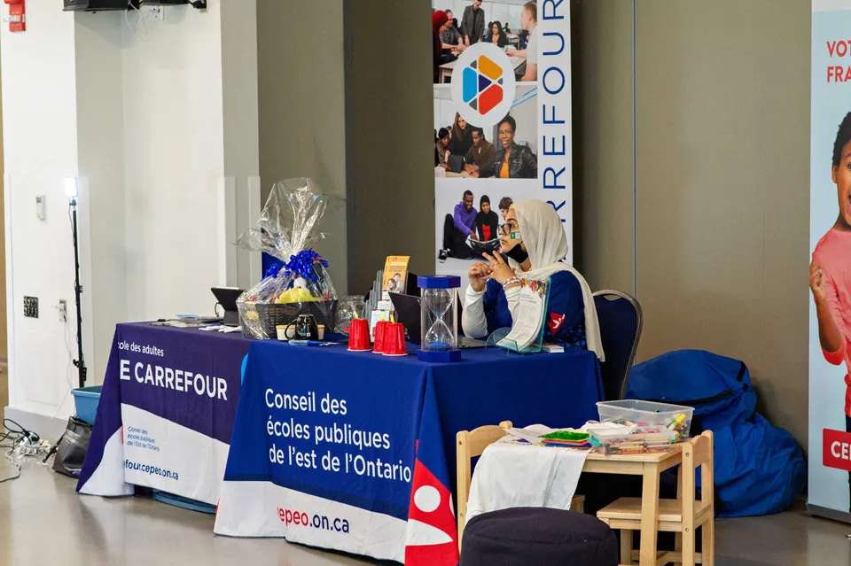 Uno stand informativo delle Eastern Ontario Public Schools con un cartello in un corridoio con poster alle pareti.