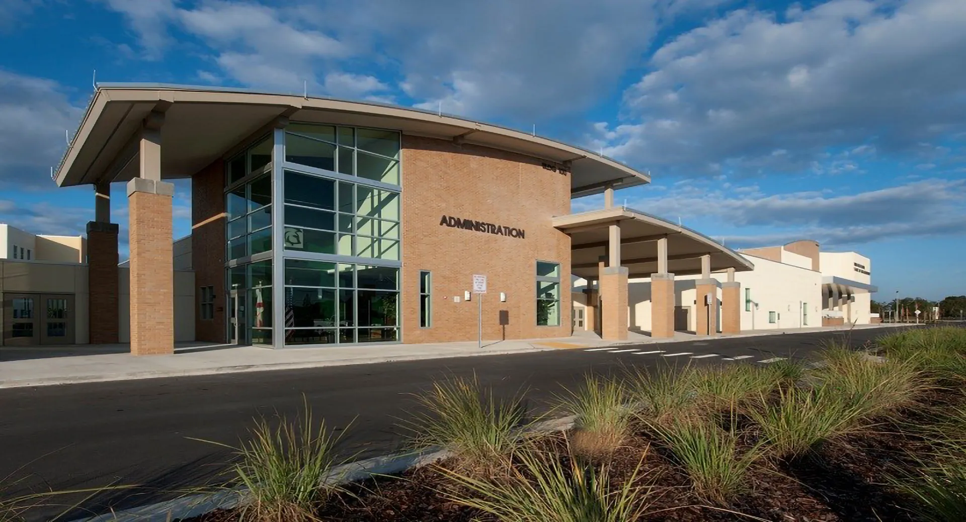 Un edificio moderno con facciata in vetro e tetto curvo nel campus delle Orange County Public Schools.