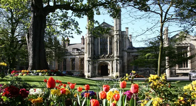Das gotische Gebäude der St. Peters School ist von einem Garten mit bunten Tulpen und anderen Blumen umgeben.