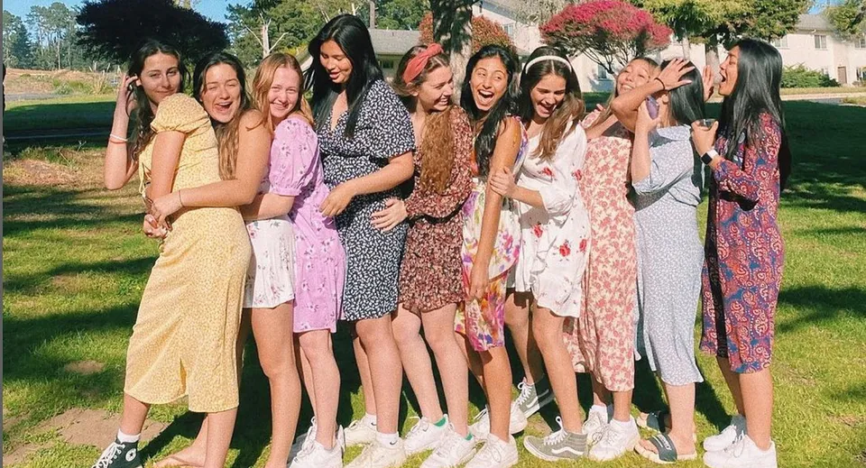 Un gruppo di studentesse della Monterey Bay Academy si abbraccia all'aperto su un prato.