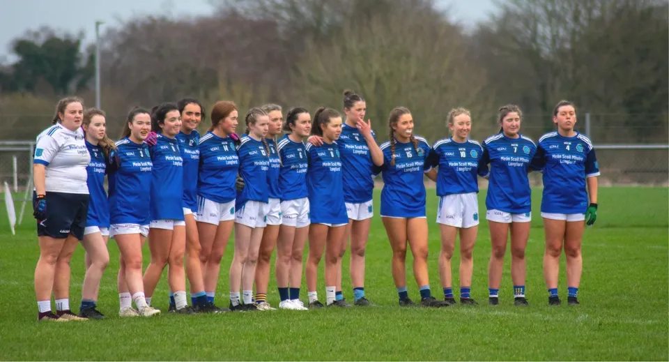 Un gruppo di giovani calciatrici si trova sul campo da gioco nel campus della Meán-Scoil Mhuire Gan Smál.