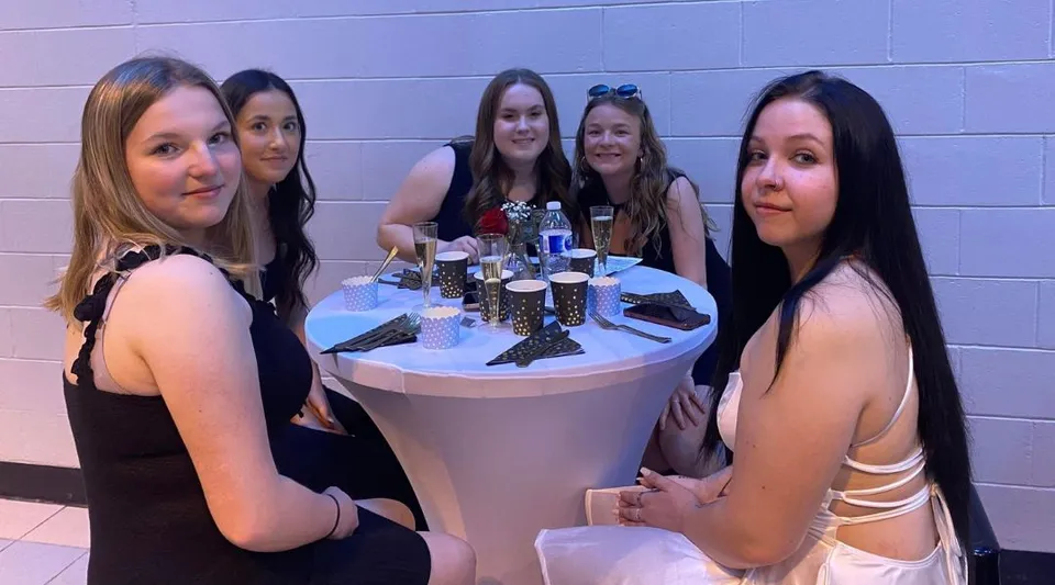 Un gruppo di giovani donne in abbigliamento formale posa insieme durante un evento alla Polyvalente Alexandre-J.-Savoie.